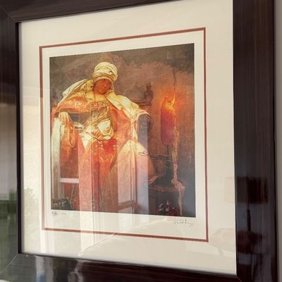 Framed and matted art print depicting a seated figure in traditional Orientalist attire by a glowing candle, signed and numbered in the...