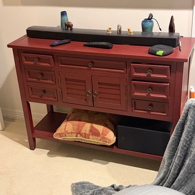 Red painted wood media console table featuring multiple drawers, louvered cabinet doors, and a lower shelf.