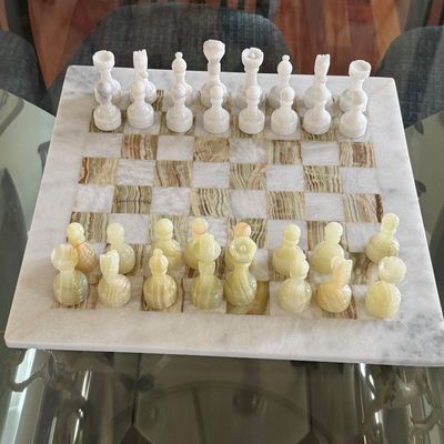 Hand-carved marble and onyx chess set with full playing pieces and matching board.