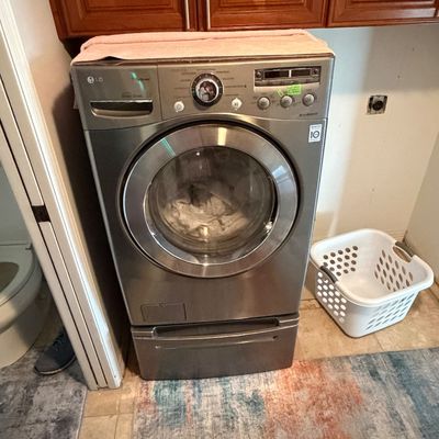 LG Direct Drive front-load washing machine in metallic graphite with a bottom pedestal drawer.
