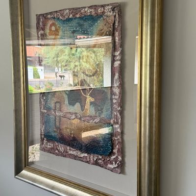 Framed contemporary mixed-media fiber artwork with gold leaf accents and textured handmade paper border, floating inside a metallic gold...