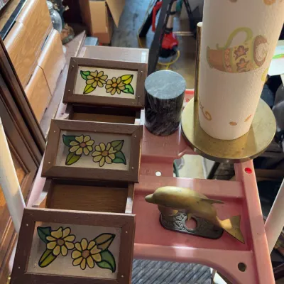 Sale Photo Thumbnail #162: Vintage floral stained glass-style tiered wooden spice rack shown alongside a brass dolphin figurine, a marble cylinder, and a paper towel holder.