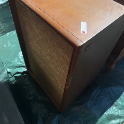 Sale Photo Thumbnail #60: Vintage mid-century floor-standing speaker cabinet featuring a wooden veneer enclosure and a woven fabric grille cover.