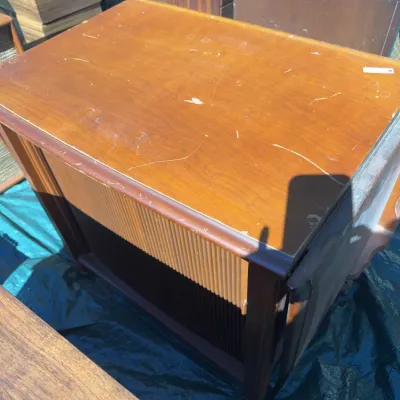 Sale Photo Thumbnail #64: Mid-century modern wooden cabinet with ribbed detailing, showing visible surface scratches and wear.