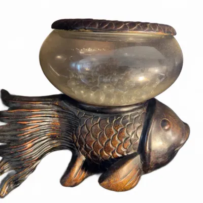 Sale Photo Thumbnail #159: Decorative fish-shaped pedestal bowl featuring a carved bronze-finish body with detailed scales and a clear glass bowl containing glass marbles.