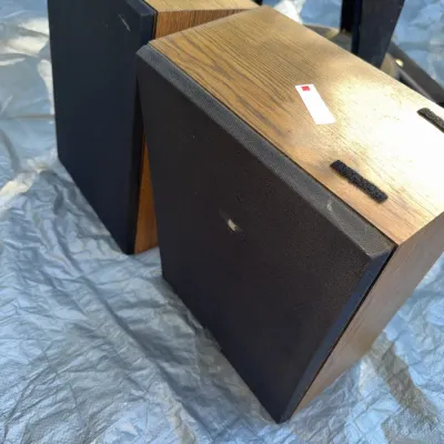 Sale Photo Thumbnail #43: Pair of vintage bookshelf speakers with wood grain vinyl cabinets and black fabric grilles.