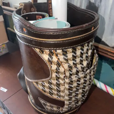 Sale Photo Thumbnail #187: Vintage leather and woven tweed golf bag containing assorted rolled posters and vinyl graphics.