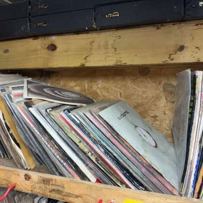 Sale Photo Thumbnail #91: Large collection of vintage vinyl LP records stacked on a wooden shelf, including albums such as Airtight.
