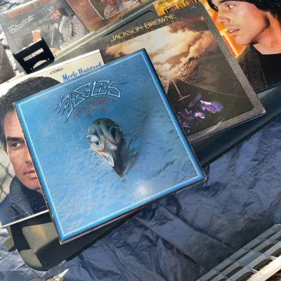 Sale Photo Thumbnail #5: Collection of classic rock and country vinyl records from the 1970s and 1980s, including albums by Eagles, Jackson Browne, and Merle Haggard.
