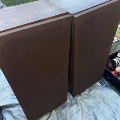 Sale Photo Thumbnail #39: Pair of vintage floor-standing stereo speakers featuring wood grain cabinets and brown fabric grilles.