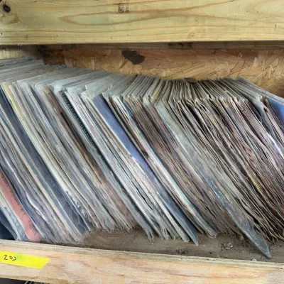 Sale Photo Thumbnail #82: Large collection of vintage vinyl LP records stacked on wooden shelving.