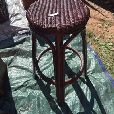 Sale Photo Thumbnail #73: Dark mahogany-stained wicker and rattan stool featuring a woven round seat and curved bentwood legs with a footrest ring.