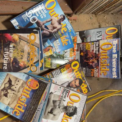 Sale Photo Thumbnail #146: Collection of vintage Outside magazine issues from the late 1990s and 2000s scattered on the floor next to shelves of vinyl records.