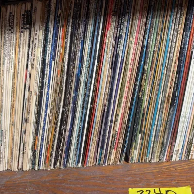 Sale Photo Thumbnail #122: Large collection of vintage vinyl LP record albums filed vertically on a wooden shelf, primarily featuring pop, country, and easy listening artists.