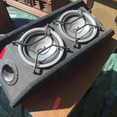 Sale Photo Thumbnail #56: Dual subwoofer car audio speaker box with metal protective grilles and a carpeted enclosure.
