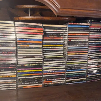 Sale Photo Thumbnail #157: Large collection of compact discs featuring various 1990s and 2000s rock, pop, and hip-hop artists, neatly stacked in jewel cases.