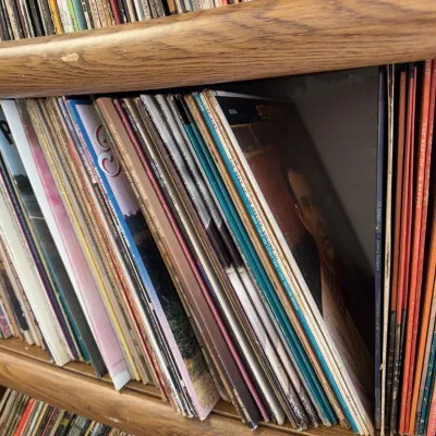 Sale Photo Thumbnail #100: Collection of vintage vinyl LP record albums, primarily country and pop genres, stored on wooden shelving units.