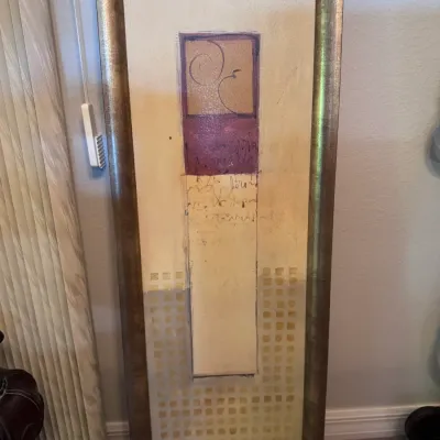 Tall, framed contemporary abstract artwork with mixed-media elements in earth tones and gold metallic trim.
