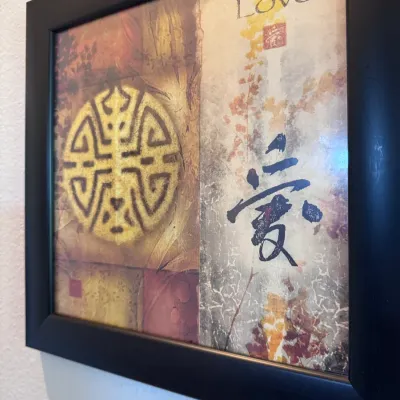 Sale Photo Thumbnail #148: Framed Asian-inspired art print featuring the word "Love" in English and Chinese calligraphy alongside decorative symbols, housed in a thick black frame.