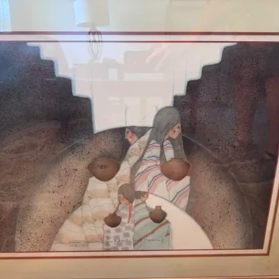 Sale Photo Thumbnail #117: Framed Southwestern style print depicting Native American figures with pottery and woven blankets, set in a double-matted wood frame under glass.