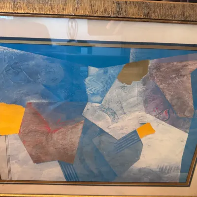 Sale Photo Thumbnail #115: Framed mid-century abstract collage artwork featuring mixed media shapes in blue, yellow, and earth tones with a textured gold frame.