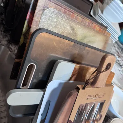 Sale Photo Thumbnail #122: Collection of modern kitchen cutting boards, including a Brandani wooden board set with cheese tools, plastic boards, and glass cutting surfaces.
