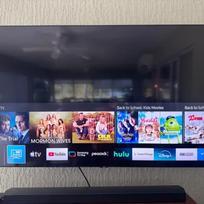 Sale Photo Thumbnail #101: Wall-mounted Samsung modern smart TV powered on, displaying media menu interface above a matching black soundbar.