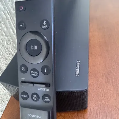 Sale Photo Thumbnail #103: Black Samsung soundbar speaker featuring a matching Samsung soundbar remote control.