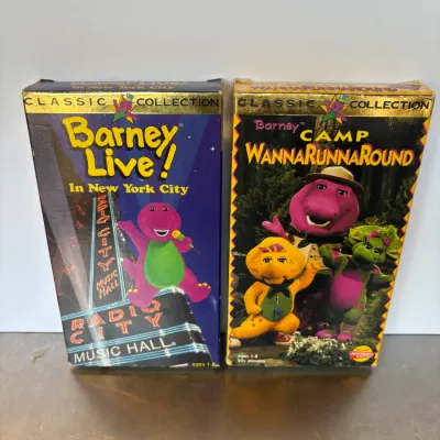 Sale Photo Thumbnail #101: Two 1990s Barney VHS tapes, including "Barney Live! In New York City" and "Camp WannaRunnaRound," from the Classic Collection series.