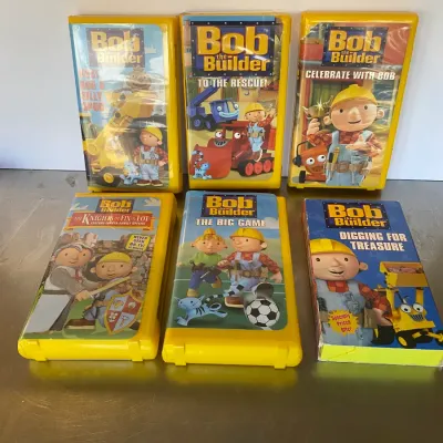 Sale Photo Thumbnail #103: Collection of six Bob the Builder VHS tapes, including early 2000s titles in yellow plastic clamshell cases and standard slipcovers.