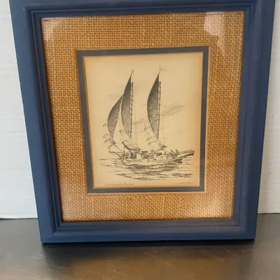 Sale Photo Thumbnail #23: Framed nautical sketch titled "Chesapeake Bugeye" by John Moll, featuring a burlap mat and blue wooden frame.
