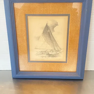 Sale Photo Thumbnail #20: Framed print titled "Chesapeake Skipjack" by John Moll, featuring a burlap mat and blue wooden frame.