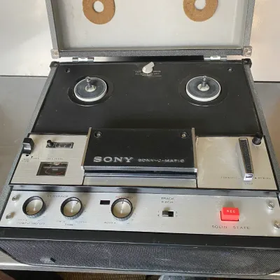 Sale Photo Thumbnail #45: Vintage Sony-O-Matic solid state reel-to-reel tape recorder housed in a portable grey carrying case.