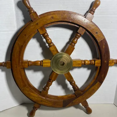 Sale Photo Thumbnail #114: Nautical wooden ship's wheel wall decor featuring six turned handles and a brass center hub.