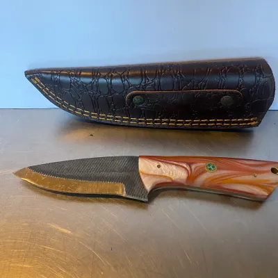 Sale Photo Thumbnail #86: Handmade file knife featuring a swirled orange and white acrylic handle with mosaic pin detail, shown alongside a dark brown faux-croc leather sheath.