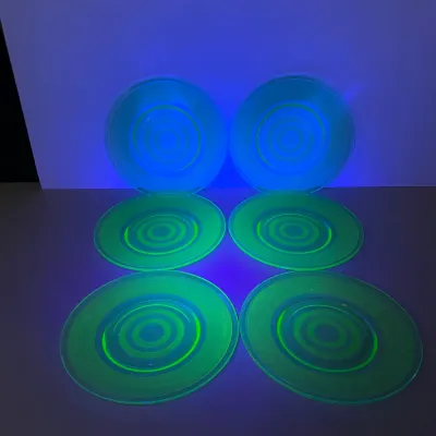 Sale Photo Thumbnail #29: Set of six Depression-era uranium glass plates featuring a concentric ring pattern glowing under blacklight.