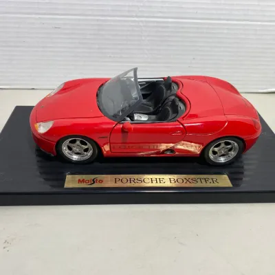 Sale Photo Thumbnail #33: Maisto 1:18 scale die-cast red Porsche Boxster convertible, mounted on its original black display stand with nameplate.