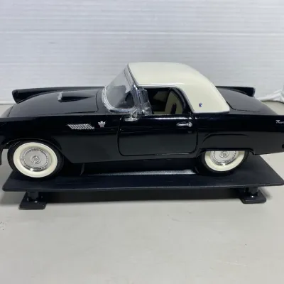 Sale Photo Thumbnail #34: Die-cast scale replica of a 1955 Ford Thunderbird in black with a white removable hardtop, mounted on a display base.
