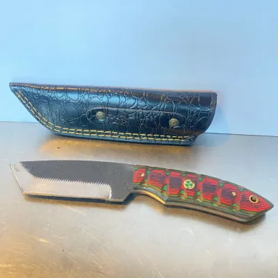 Sale Photo Thumbnail #54: Custom fixed-blade hunting knife made from a file blade, featuring a red and green Pakkawood handle with mosaic pins and a fitted black leather sheath.