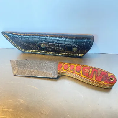 Sale Photo Thumbnail #51: Custom Damascus steel cleaver-style fixed-blade knife featuring a multi-color laminated handle and a black faux-croc leather sheath.