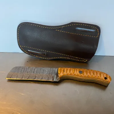 Sale Photo Thumbnail #90: Custom Damascus steel cleaver-style fixed blade knife featuring a textured wood handle with a mosaic pin, paired with a heavy-duty brown leather belt sheath.