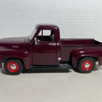 Sale Photo Thumbnail #35: Die-cast scale replica of a 1953 Ford F-100 pickup truck in maroon with red wheels and chrome accents.