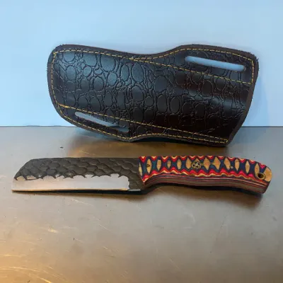 Sale Photo Thumbnail #62: Custom fixed-blade cleaver knife with a textured spine, multicolored wood laminate handle, and a matching embossed leather belt sheath.