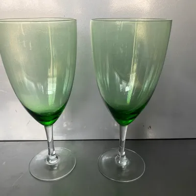 Sale Photo Thumbnail #42: Pair of vintage green glass wine goblets featuring clear stems and bases.