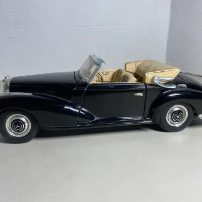 Sale Photo Thumbnail #37: Vintage die-cast model of a black Mercedes-Benz convertible with a tan interior and chrome accents.