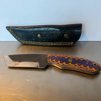 Sale Photo Thumbnail #70: Custom fixed-blade knife crafted from a steel file, featuring a purple and orange layered wood handle with a mosaic pin, accompanied by a black faux-alligator leather sheath.