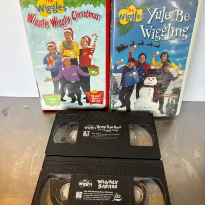 Sale Photo Thumbnail #102: Collection of four The Wiggles VHS tapes, including two cased Christmas titles and two loose tapes.