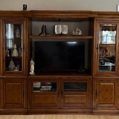 Sale Photo Thumbnail #9: Large wooden entertainment center with glass display cabinets, lower storage doors, and a central TV cavity.