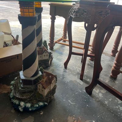 Sale Photo Thumbnail #6: Pair of novelty glass-top side tables with resin black-and-white spiral lighthouse bases featuring detailed cottage scenes at the bottom.