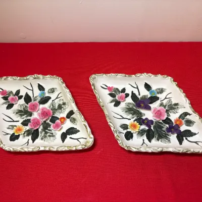 Pair of vintage diamond-shaped ceramic trays featuring applied floral porcelain accents and gilt trim.